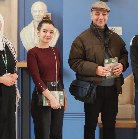 A group of four smiling people standing in front of a Reading Museum gallery display